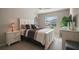 Neutral bedroom features a large bed with stylish bedding, light-colored floors, and bright natural light at 5754 Shealy Ave, The Villages, FL 32163