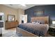 Bedroom showcases a unique accent wall, a well-dressed bed, and light-colored wood flooring at 5754 Shealy Ave, The Villages, FL 32163