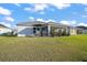 A full lawn and outdoor seating area add to the appeal of this screened-in home at 5754 Shealy Ave, The Villages, FL 32163