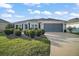 Charming home with landscaped front yard, two-car garage, and well-maintained lawn at 5754 Shealy Ave, The Villages, FL 32163