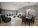 Open-concept living room with comfortable seating, dining area, and sliding glass doors to the backyard at 5754 Shealy Ave, The Villages, FL 32163