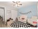 Bedroom featuring a blue accent wall, white crib, a checkered rug, and natural light at 6873 Sw 131St Pl, Ocala, FL 34473