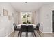 Bright dining area with table set for six, modern lighting, and peaceful window view at 6873 Sw 131St Pl, Ocala, FL 34473