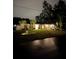 Charming single-story home with manicured lawn, palm trees, and a two-car garage on a well-lit lot at night at 6873 Sw 131St Pl, Ocala, FL 34473