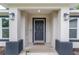 Close up of the front porch with an attractive front door, lighting and a Lion door mat at 6873 Sw 131St Pl, Ocala, FL 34473