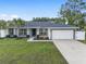 Charming single-story home showcasing a well-manicured lawn, attached garage and inviting curb appeal at 6873 Sw 131St Pl, Ocala, FL 34473