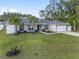 Inviting single-story home featuring a well-manicured lawn, palm trees, and an attached two-car garage at 6873 Sw 131St Pl, Ocala, FL 34473