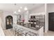 Modern kitchen featuring stainless appliances, stone countertops, and stylish pendant lighting at 6873 Sw 131St Pl, Ocala, FL 34473