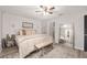 Spacious main bedroom with neutral decor, a plush bed, bench, and a large mirror at 6873 Sw 131St Pl, Ocala, FL 34473