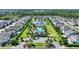 An aerial view of a community clubhouse, swimming pool, playground, and pond, surrounded by beautifully landscaped grounds at 7752 Moser Ave, Windermere, FL 34786