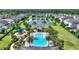 Aerial view showcases a community pool and playground area, complete with lush landscaping and a picturesque pond at 7752 Moser Ave, Windermere, FL 34786