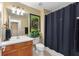 Neutral bathroom with vanity, black accents, shower curtain and toilet at 7752 Moser Ave, Windermere, FL 34786