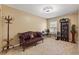 Neutral bedroom with a vintage couch, small desk, carpet and natural light from a large window at 7752 Moser Ave, Windermere, FL 34786