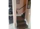 A view of the staircase with hardwood steps, black railing, and a neutral painted wall at 2605 Gala S Rd, Kissimmee, FL 34746
