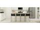 Bright, white kitchen with modern stainless steel appliances, bar stool seating, and ample counter space at 2022 Lasso Loop, Eagle Lake, FL 33839