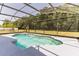 A beautiful screened-in pool is surrounded by green space and trees at 2433 Huron Cir, Kissimmee, FL 34746