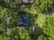 An overhead aerial view of the property featuring a green lawn, mature trees, and storage shed at 5434 Se 39Th Ave, Ocala, FL 34480