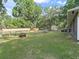 A spacious backyard with lush green grass, mature trees, a fenced area, a fire pit, and a shed at 5434 Se 39Th Ave, Ocala, FL 34480