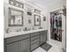 Well-lit bathroom features double sinks, gray cabinets, framed mirrors and an adjacent walk-in closet at 5434 Se 39Th Ave, Ocala, FL 34480