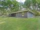 A charming home exterior featuring a lush green lawn, screened porch, and mature trees at 5434 Se 39Th Ave, Ocala, FL 34480