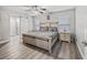 A well-lit bedroom with wood flooring, ceiling fan, and barn door to the en suite at 5434 Se 39Th Ave, Ocala, FL 34480