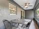 A shaded patio area with metal furniture and a ceiling fan offers a cozy outdoor space for relaxation and entertaining at 5434 Se 39Th Ave, Ocala, FL 34480