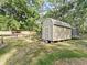 Exterior view of a well-maintained shed with a sturdy door, offering practical storage in a green backyard at 5434 Se 39Th Ave, Ocala, FL 34480