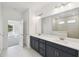 Bright bathroom boasts a double sink vanity, quartz countertop, and tiled shower at 5944 Bristle Oak St, Mount Dora, FL 32757