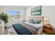 Well-lit bedroom features a plush bed with stylish blue accents and a large window with neighborhood views at 5944 Bristle Oak St, Mount Dora, FL 32757