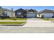 A view of the neighborhood with the charming single-story house, featuring a two-car garage and front lawn at 5944 Bristle Oak St, Mount Dora, FL 32757