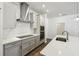 Modern kitchen boasts stainless steel appliances, white cabinetry, and an island with sink at 5944 Bristle Oak St, Mount Dora, FL 32757