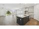Open-concept kitchen featuring a large island, sleek countertops, modern appliances, and an adjacent living space at 5944 Bristle Oak St, Mount Dora, FL 32757