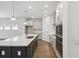 Modern kitchen featuring a large island, sleek countertops, pendant lighting, and stainless steel appliances at 5944 Bristle Oak St, Mount Dora, FL 32757