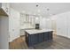 Stylish kitchen featuring a spacious island, quartz countertops, modern lighting, and stainless steel appliances at 5944 Bristle Oak St, Mount Dora, FL 32757