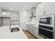 Open kitchen with stainless appliances, white cabinets, island, and pendant lighting at 5944 Bristle Oak St, Mount Dora, FL 32757