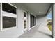 A covered back porch with large windows and a door, overlooking the backyard and lawn at 6087 Sacred Oak Ave, Mount Dora, FL 32757