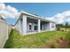 View of the backyard featuring a covered porch, newly installed lawn, and rear elevation of home at 6087 Sacred Oak Ave, Mount Dora, FL 32757