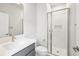 Bright bathroom with a glass enclosed shower, and a gray vanity with a white countertop and modern gold faucet at 6087 Sacred Oak Ave, Mount Dora, FL 32757