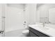 Modern bathroom featuring tiled tub/shower, a white vanity, and sleek fixtures at 6087 Sacred Oak Ave, Mount Dora, FL 32757