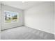 Bedroom with plush carpeting and a window overlooking the neighborhood at 6087 Sacred Oak Ave, Mount Dora, FL 32757