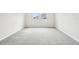 A spacious, carpeted bedroom with two large windows offering ample natural light at 6087 Sacred Oak Ave, Mount Dora, FL 32757