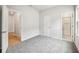 A carpeted bedroom with a view of the bathroom and hardwood hallway through the open doors at 6087 Sacred Oak Ave, Mount Dora, FL 32757