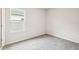 An empty, carpeted bedroom with a double hung window letting in natural light and white trim throughout at 6087 Sacred Oak Ave, Mount Dora, FL 32757