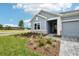 Attractive home with light blue siding and a well-maintained lawn, showcasing the welcoming entrance and landscaping at 6087 Sacred Oak Ave, Mount Dora, FL 32757
