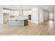 Bright, open kitchen with white cabinets, a gray island, stainless steel appliances, and modern pendant lighting above island at 6087 Sacred Oak Ave, Mount Dora, FL 32757