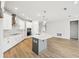 Spacious kitchen featuring white cabinetry, a large island with seating, stainless steel appliances, and a modern design at 6087 Sacred Oak Ave, Mount Dora, FL 32757