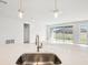 Kitchen island with stainless steel sink and modern faucet offers backyard views and bright, open floor plan at 6087 Sacred Oak Ave, Mount Dora, FL 32757