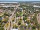 Aerial view with a green arrow showing the home among mature trees, neighborhood streets, and community spaces at 701 N Vermont Ave, Lakeland, FL 33801