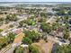 Aerial view with a green arrow emphasizing the home's location within a leafy neighborhood near community amenities at 701 N Vermont Ave, Lakeland, FL 33801