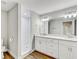 Bathroom featuring white cabinets, double sinks, shower with subway tile and wood-look flooring at 701 N Vermont Ave, Lakeland, FL 33801